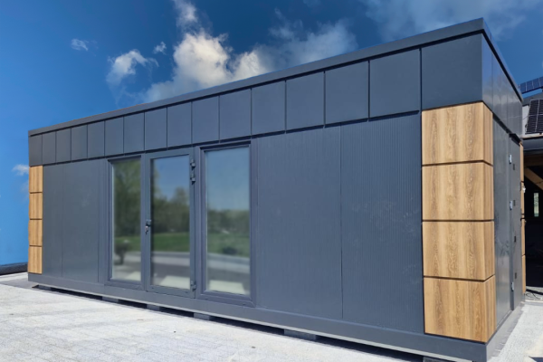 Dark grey modular portable cabin with oak timber accent panels and central aluminium glazed double doors