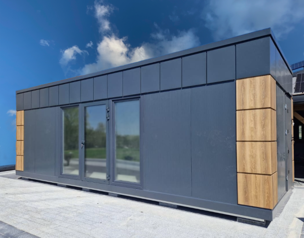 Dark grey modular portable cabin with oak timber accent panels and central aluminium glazed double doors