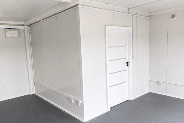 Open-plan modular office interior fitted with desks, monitors, office chairs Emma 2