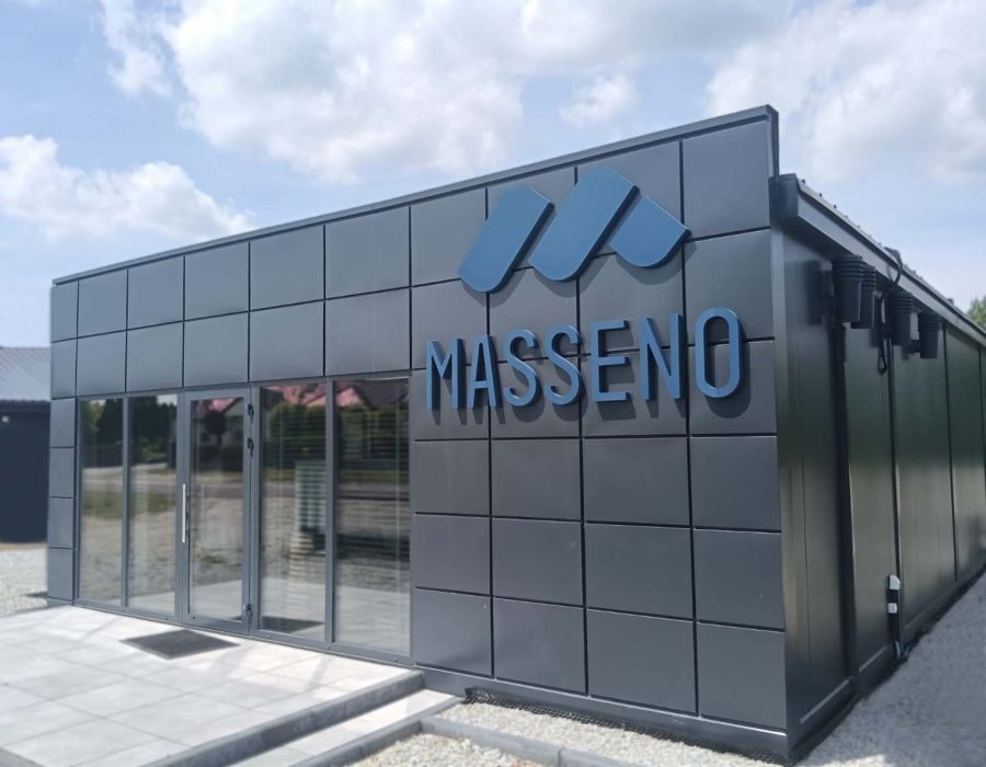 Dark grey modular commercial building with panel cladding, glazed entrance and Masseno branding on facade