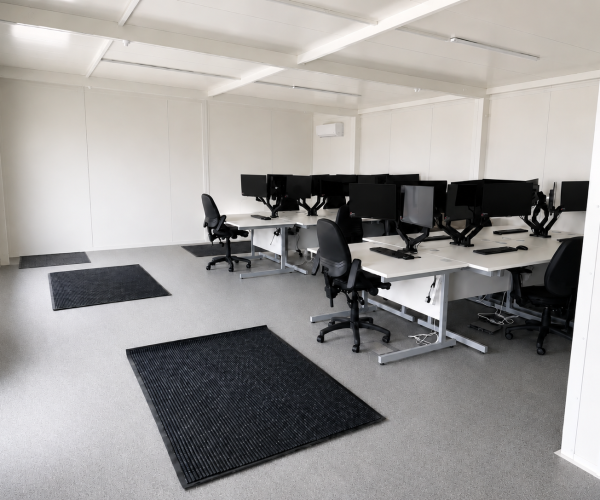 Open-plan modular office interior fitted with desks, monitors, office chairs and wall-mounted air conditioning