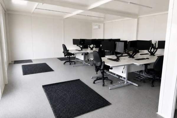 Open-plan modular office interior fitted with desks, monitors, office chairs and wall-mounted air conditioning