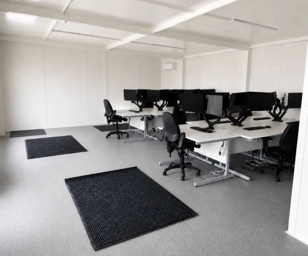 Open-plan modular office interior fitted with desks, monitors, office chairs and wall-mounted air conditioning
